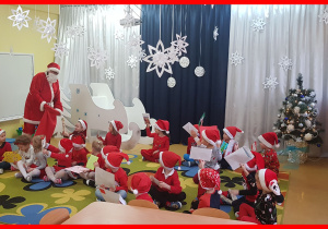 Dzieci z Biedronek na tle zimowej dekoracji w swojej sali z Mikołajem